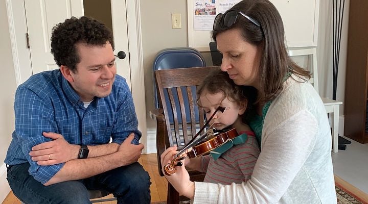 parents with child and violin