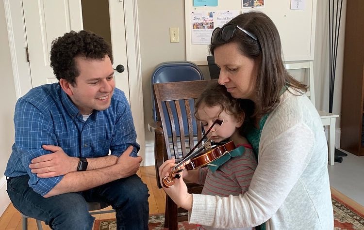 parents with child and violin