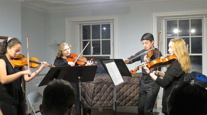 Four teenage violinists developing ensemble skills