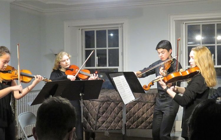 Four teenage violinists developing ensemble skills