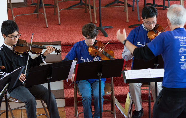 student violinists with conductor