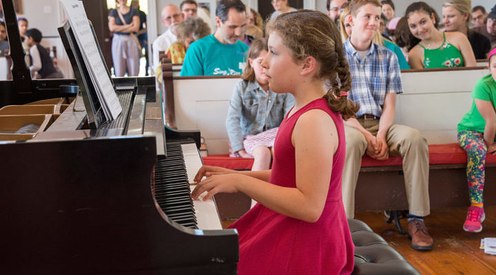 child playing the piano at a recital