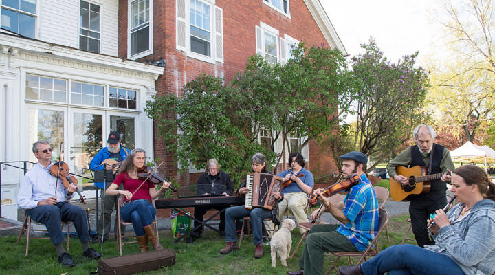 folks sitting outside playing fiddle tunes on various instruments