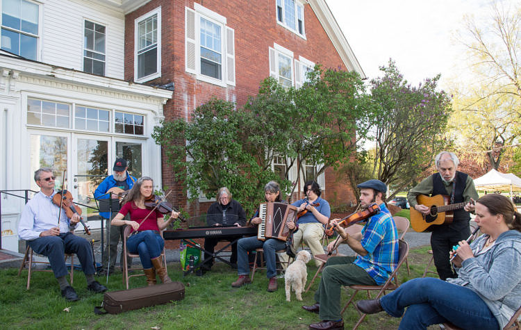 folks sitting outside playing fiddle tunes on various instruments