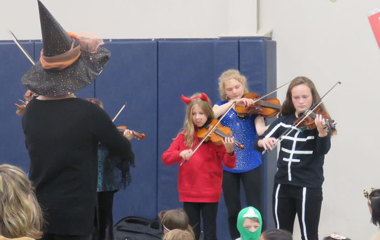 students in costume playing violin