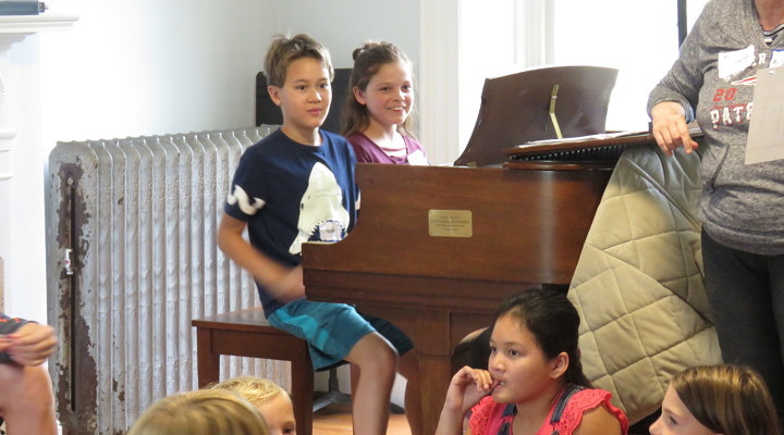 two children seated at a piano