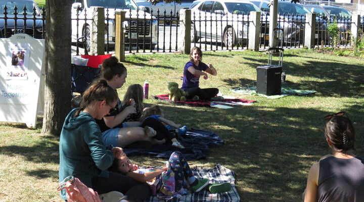 A family enjoys music class with young children.