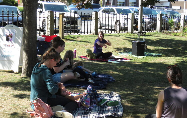 A family enjoys music class with young children.
